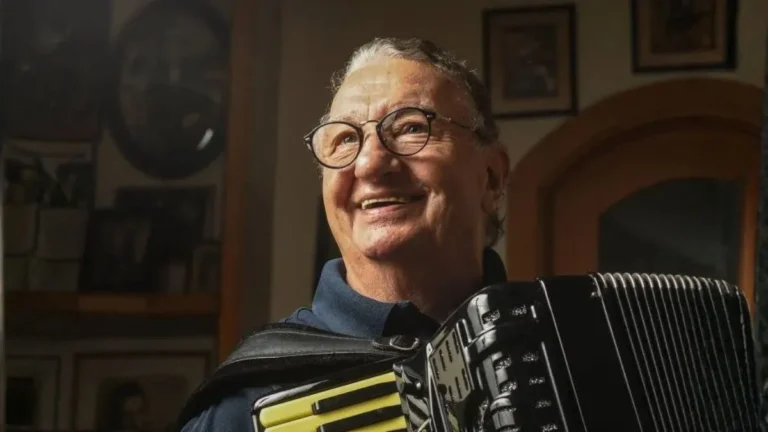 Caçulinha, Músico Do Domingão Do Faustão, Sorrindo Enquanto Toca Acordeon Em Ambiente Interno
