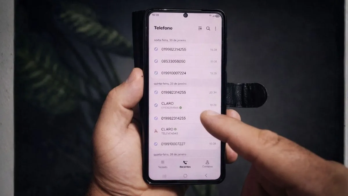 Pessoa segura o celular com nítida expressão de incômodo ao receber várias chamadas de números desconhecidos em sequência.