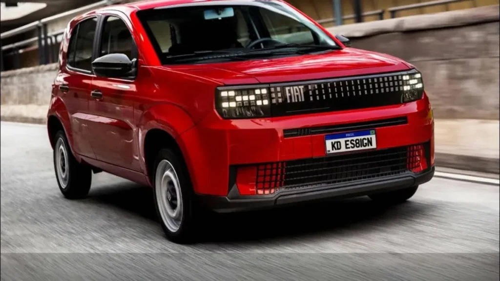 Hatch Compacto Da Fiat Em Movimento, Com Visual Moderno, Faróis Em Led, Frente Robusta E Pintura Vermelha, Destacando A Nova Identidade Da Marca