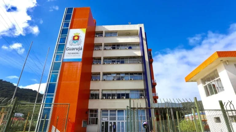 Prédio Do Paço Municipal De Guarujá Com Fachada Laranja E Branca E Nome Da Cidade Em Destaque, Sede Da Prefeitura Que Abriu Concurso Na Área Da Educação Em 2026.