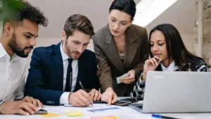 Equipe Corporativa Em Ambiente De Trabalho Analisando Tarefas Sob Pressão, Ilustrando Riscos Psicossociais E Impactos Da Nr-01 Na Rotina Das Empresas.