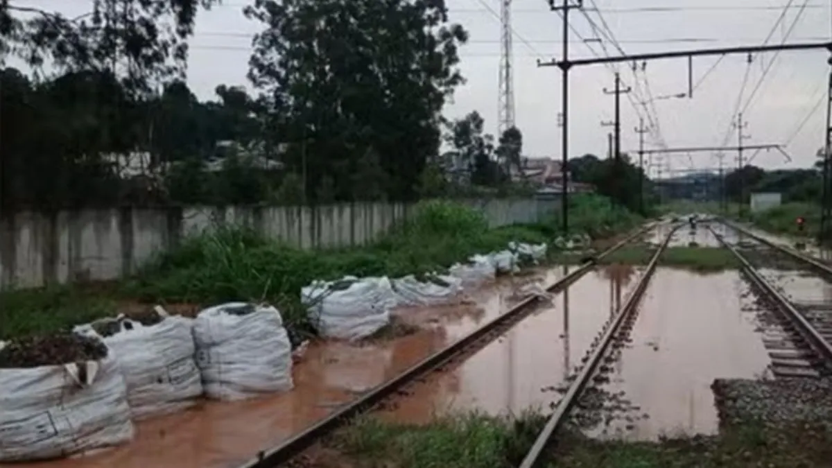Trilhos da Linha 7-Rubi alagados em trechos entre Jundiaí e Francisco Morato, com água acumulada sobre a via férrea e sacos de contenção posicionados ao lado da ferrovia.