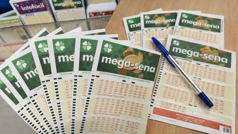 Volantes Da Mega-Sena Espalhados Sobre Uma Mesa Com Caneta Azul, Representando Apostas Para Concurso Com Prêmio Milionário