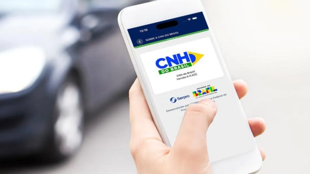 Motorista Usando Celular Para Renovar Cnh Enquanto Observa Tela Com Atenção Para Evitar Golpes