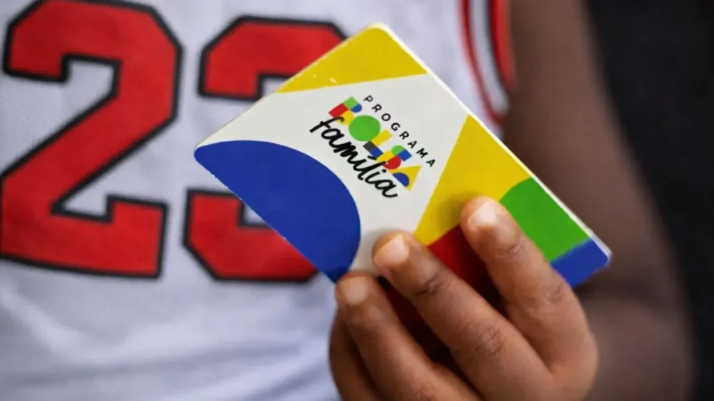 Mão De Criança Segurando Cartão Do Bolsa Família Com Camiseta De Basquete Ao Fundo E Número Grande Desfocado