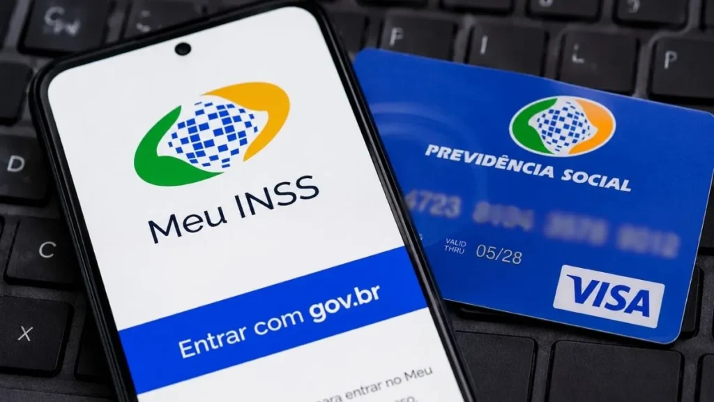 Aplicativo Meu Inss Aberto Em Smartphone Ao Lado De Cartão Da Previdência Social Em Imagem Sobre Biometria, Acesso Digital E Validação De Benefícios Sociais