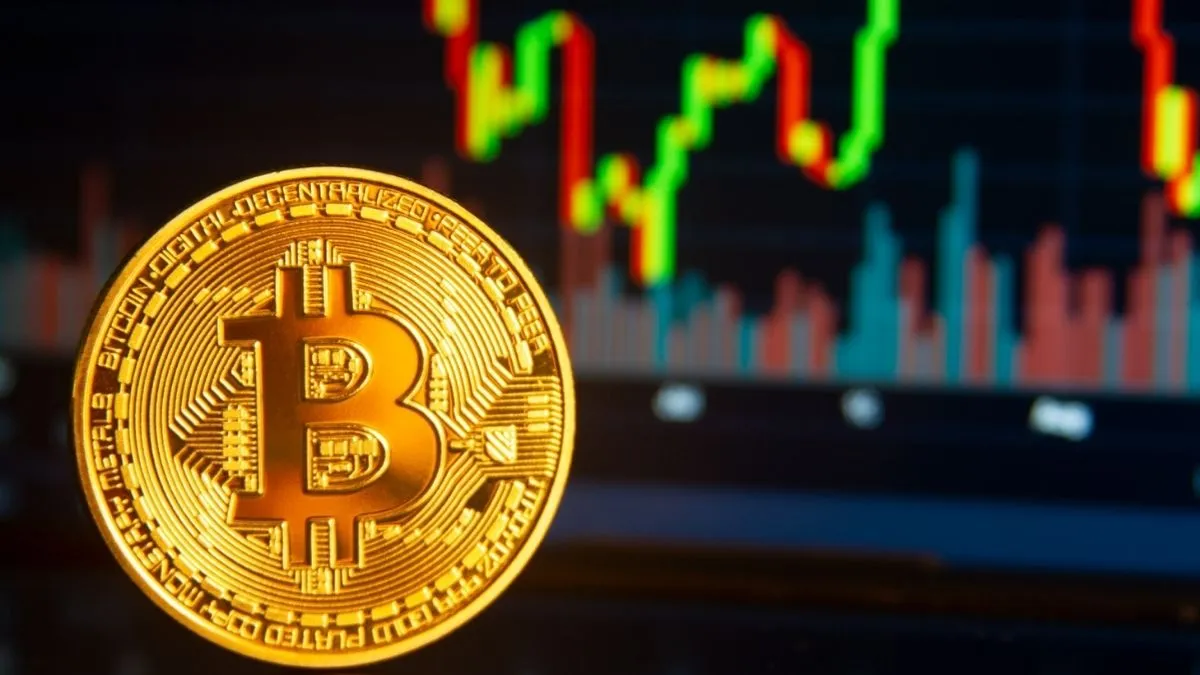 Moeda de Bitcoin em destaque diante de gráfico financeiro com fortes oscilações de alta e baixa durante semana decisiva para o mercado de criptomoedas.
