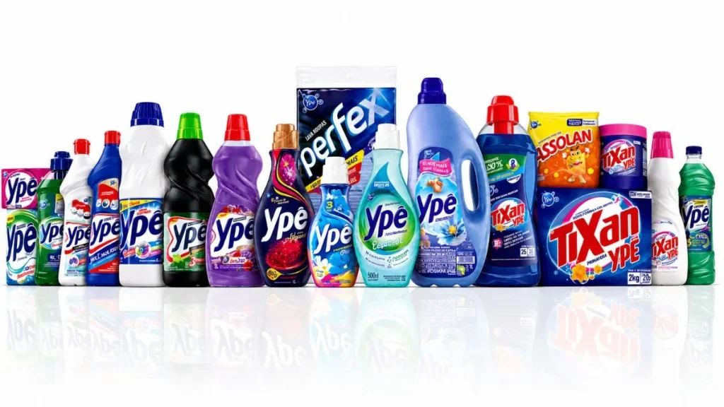 Linha Completa De Produtos Ypê, Tixan Ypê E Assolan Organizada Sobre Fundo Branco Em Imagem Publicitária Com Embalagens De Detergentes, Sabão Em Pó E Produtos De Limpeza Doméstica.