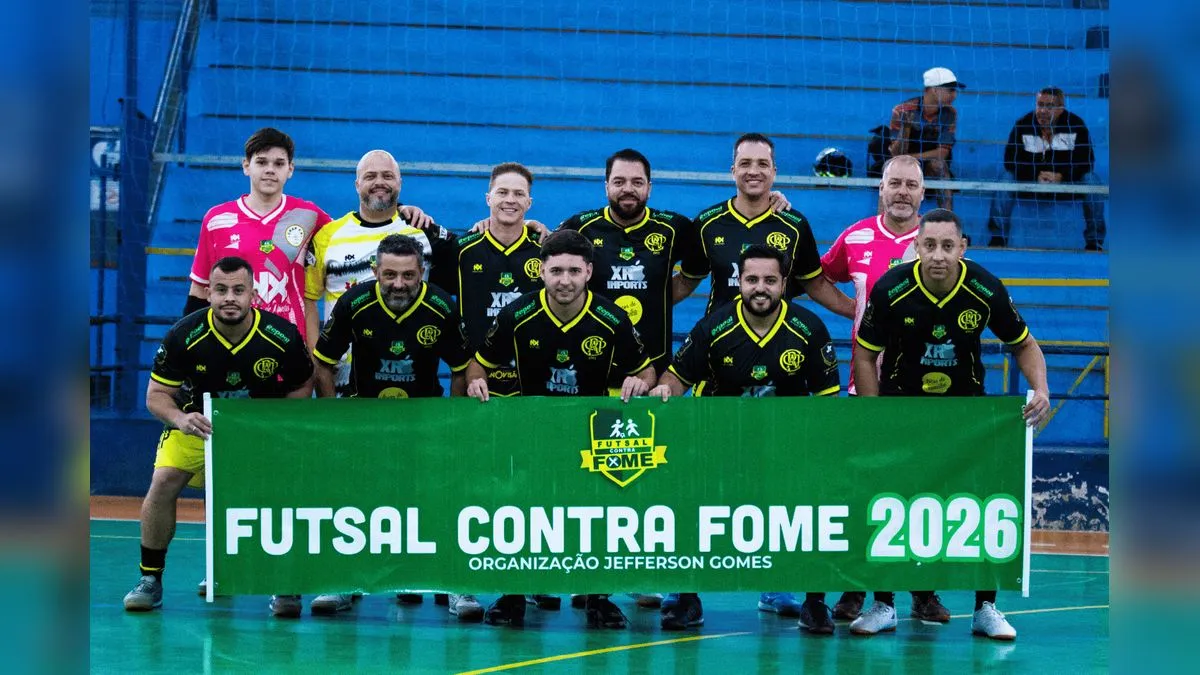 Atletas do Futsal contra Fome seguram faixa do evento em quadra durante ação solidária em Caieiras.