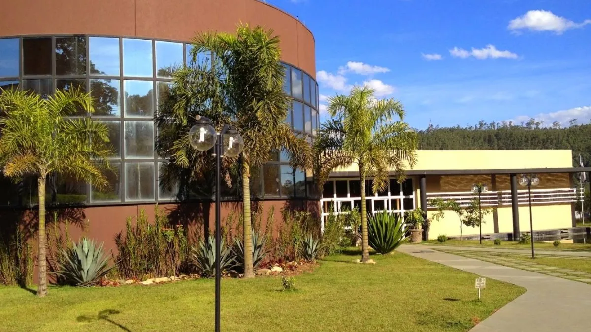 Prédio público de Cajamar com fachada envidraçada, jardim e palmeiras.