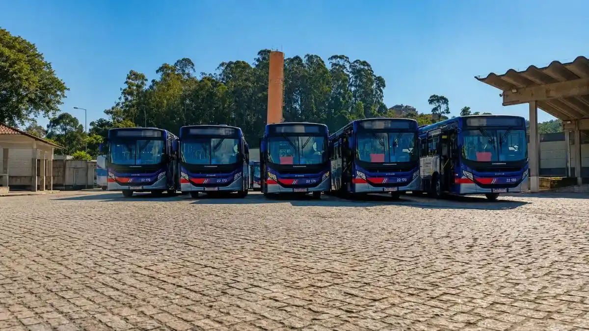 Cinco ônibus metropolitanos da Viação Caieiras alinhados em pátio aberto durante o dia.