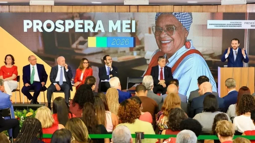 Autoridades e representantes do governo federal participam de cerimônia de apresentação do Prospera MEI 2026, diante de plateia, com painel do programa ao fundo.