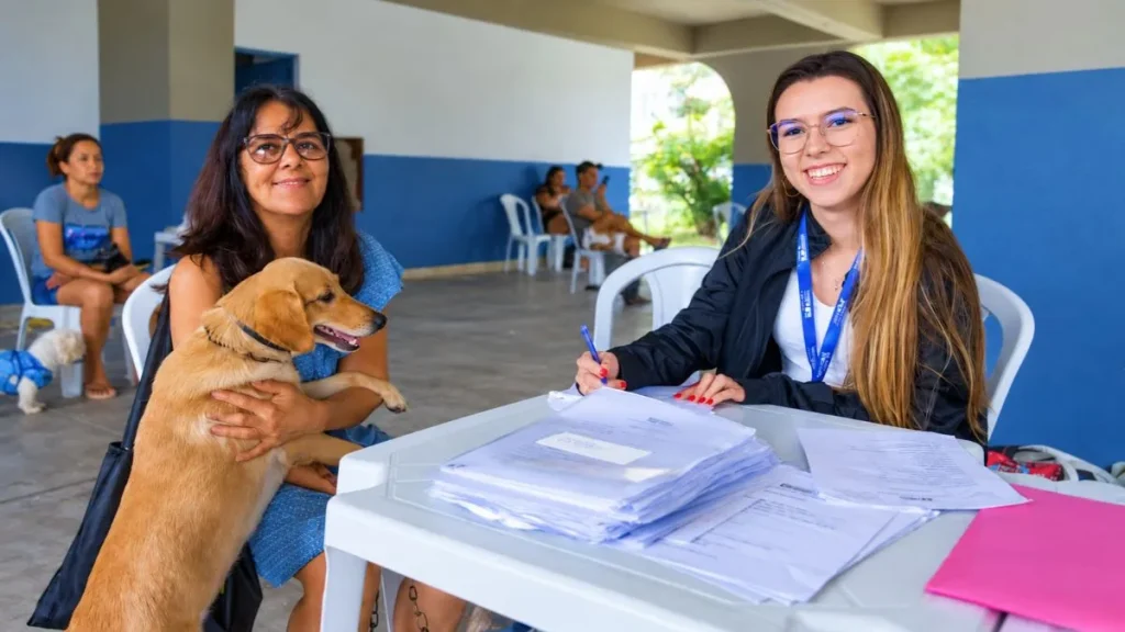 Tutora segura um cão durante atendimento de cadastro em ação pública voltada à castração e ao bem-estar animal.